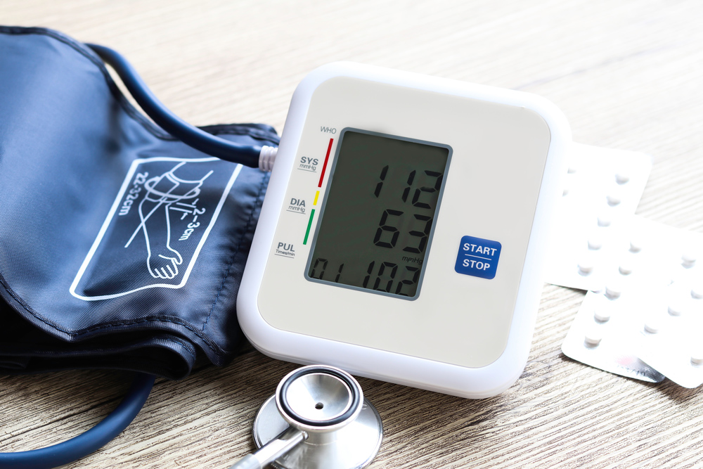 Digital Blood Pressure Monitor on  Wooden background Health and Medical concept